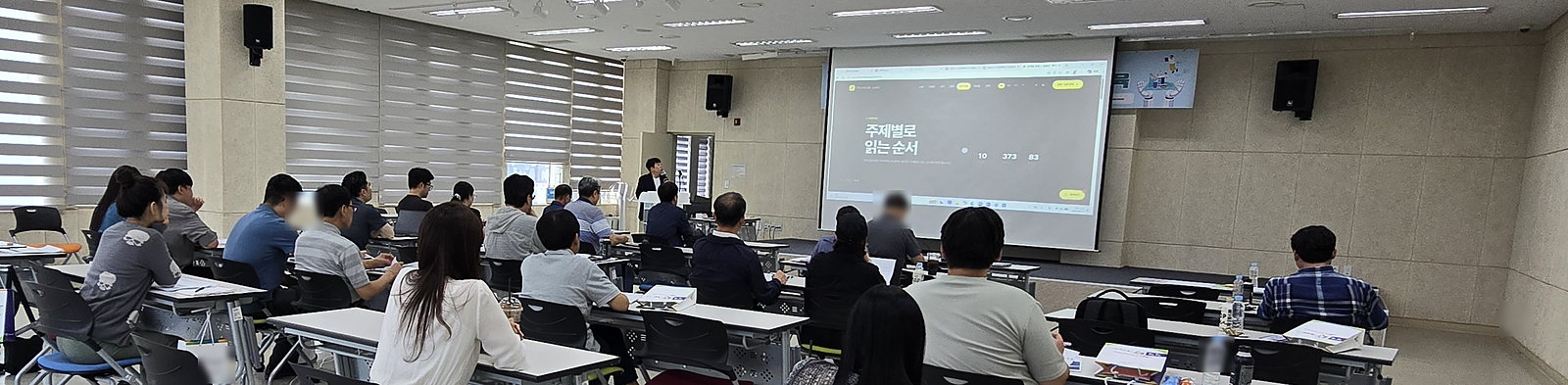 강의실 뒤쪽에서 본 전경. 화면에는 주제별로 읽는 순서 페이지가 떠 있다